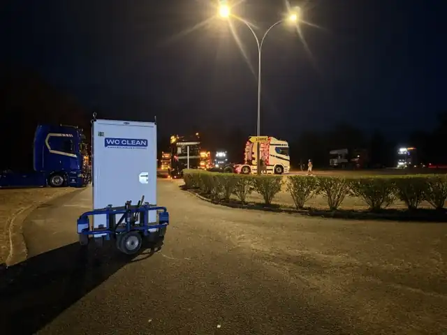 Cabine WC Clean sur remorque, de nuit sur un parking